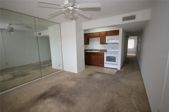 1235 S Highland Ave Unit 5-209, Clearwater, FL 33756 - kitchen featuring white appliances, a ceiling fan, light carpet, and brown cabinetry