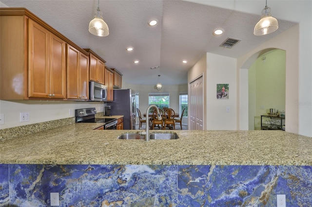 15403 Fire Rock Pl, Ruskin, FL 33573 - kitchen with stainless steel appliances, recessed lighting, arched walkways, pendant lighting, and brown cabinets