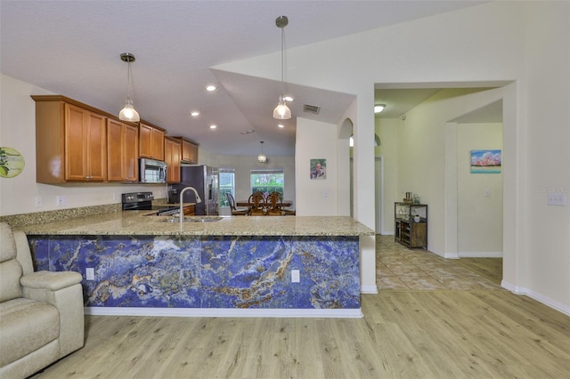 15403 Fire Rock Pl, Ruskin, FL 33573 - kitchen with lofted ceiling, appliances with stainless steel finishes, a peninsula, light wood finished floors, and arched walkways