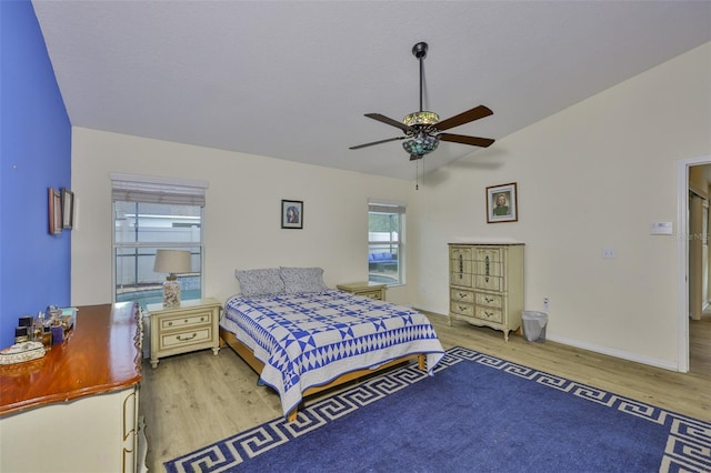 15403 Fire Rock Pl, Ruskin, FL 33573 - bedroom with wood finished floors, multiple windows, vaulted ceiling, and ceiling fan