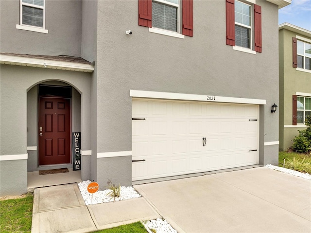 2023 Maple Ridge Dr, Zellwood, FL 32798 - view of front of home with a garage, stucco siding, and driveway