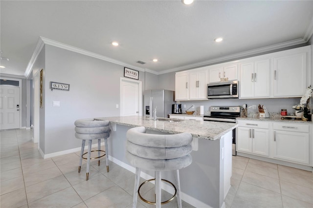 2023 Maple Ridge Dr, Zellwood, FL 32798 - kitchen featuring stainless steel appliances, crown molding, an island with sink, light tile patterned floors, and white cabinetry