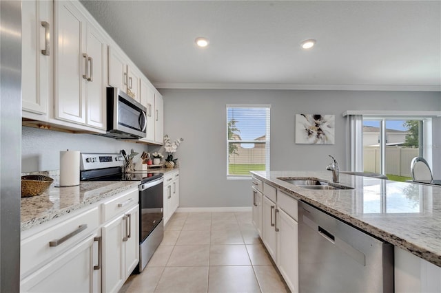 2023 Maple Ridge Dr, Zellwood, FL 32798 - kitchen with stainless steel appliances, crown molding, light stone countertops, white cabinets, and light tile patterned floors