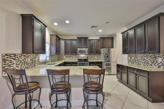 2605 Stardale Way, Lutz, FL 33558 - kitchen with appliances with stainless steel finishes, a peninsula, light stone countertops, crown molding, and recessed lighting
