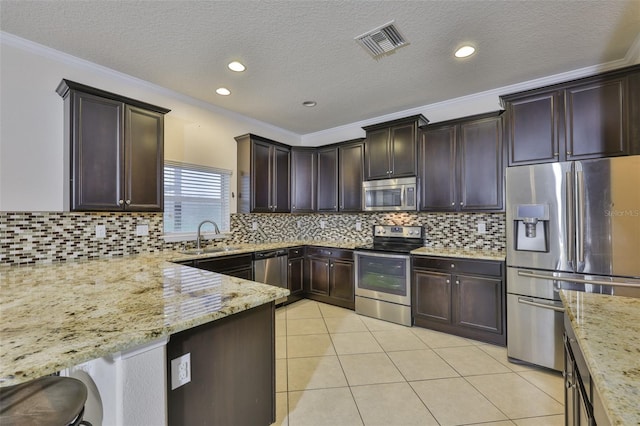 2605 Stardale Way, Lutz, FL 33558 - kitchen featuring appliances with stainless steel finishes, light stone counters, dark brown cabinets, crown molding, and light tile patterned flooring