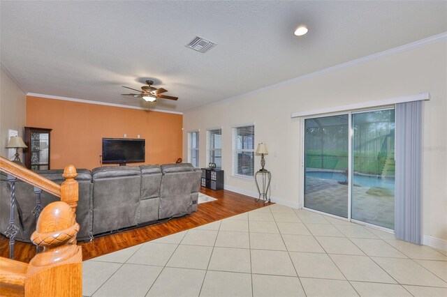 2605 Stardale Way, Lutz, FL 33558 - living room featuring ornamental molding, ceiling fan, tile patterned floors, and a textured ceiling