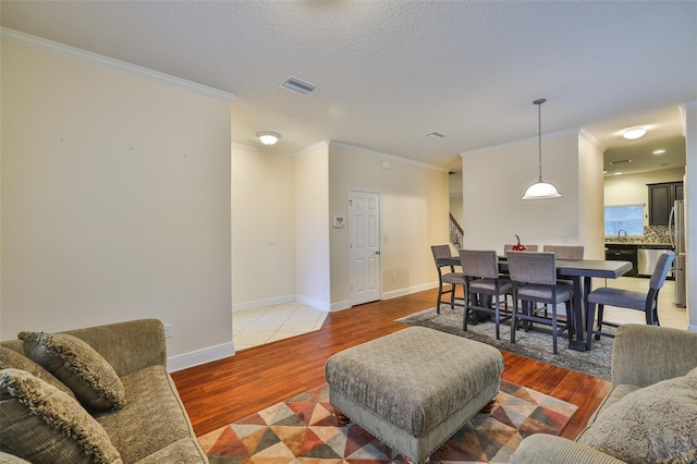 2605 Stardale Way, Lutz, FL 33558 - living room with light wood finished floors, crown molding, and stairs
