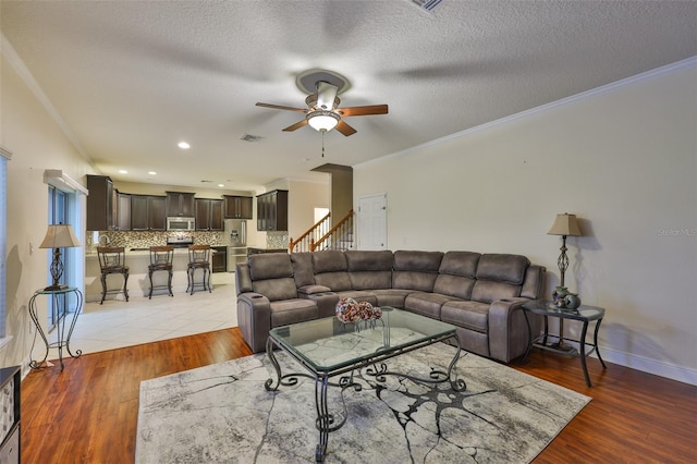2605 Stardale Way, Lutz, FL 33558 - living area with ceiling fan, crown molding, light wood finished floors, a textured ceiling, and recessed lighting