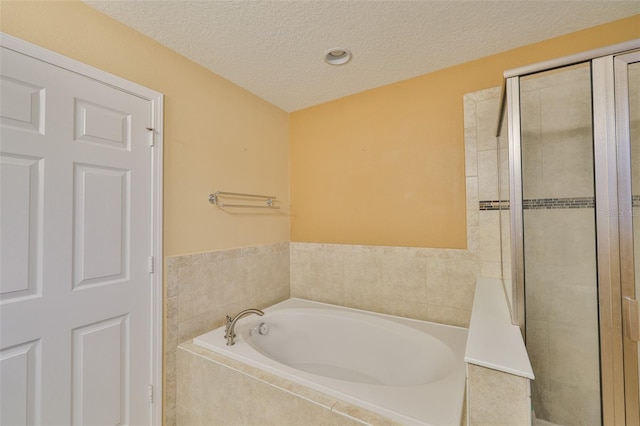 2605 Stardale Way, Lutz, FL 33558 - full bathroom featuring a garden tub, a textured ceiling, and a tile shower