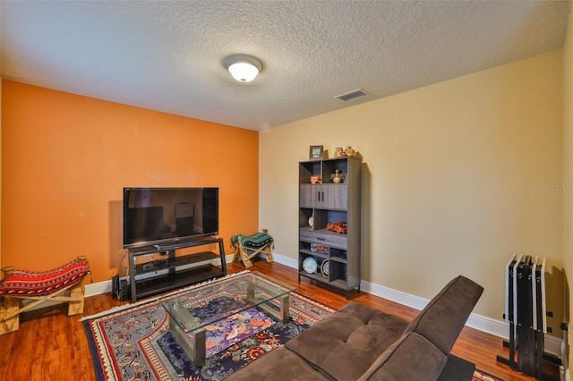 2605 Stardale Way, Lutz, FL 33558 - living room featuring wood finished floors, radiator, and a textured ceiling