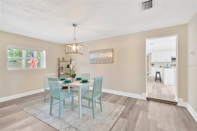 4723 Bloomingdale Ave, Valrico, FL 33596 - dining room with a chandelier and light wood-style floors