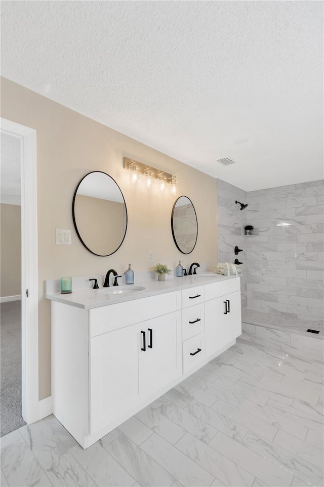 4723 Bloomingdale Ave, Valrico, FL 33596 - bathroom with marble finish flooring, double vanity, a textured ceiling, and tiled shower