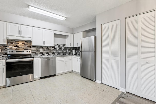 923 April Hills Blvd, Lady Lake, FL 32159 - kitchen featuring stainless steel appliances, under cabinet range hood, tasteful backsplash, white cabinetry, and a textured ceiling
