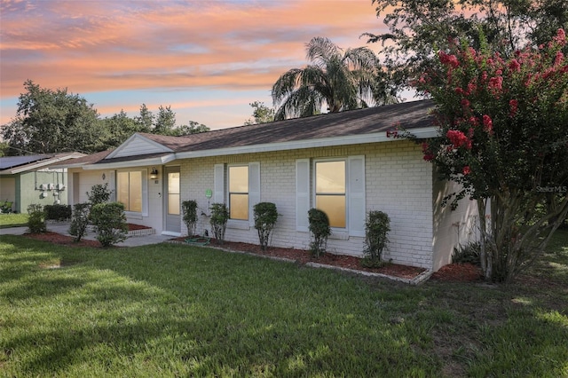 923 April Hills Blvd, Lady Lake, FL 32159 - ranch-style home with brick siding, a front lawn, and roof with shingles