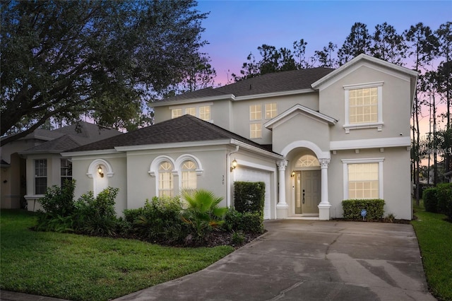 320 Tupelo Cir, Davenport, FL 33897 - view of front facade with stucco siding, an attached garage, driveway, and a front yard