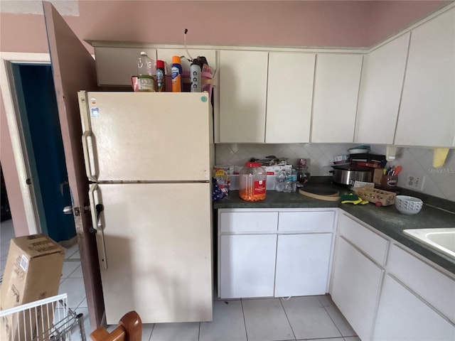 16107 Sea Pines Dr, Hudson, FL 34667 - kitchen featuring freestanding refrigerator, backsplash, light tile patterned floors, and dark countertops