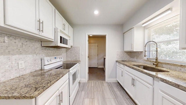 8609 N 11th St, Tampa, FL 33604 - kitchen with white appliances, decorative backsplash, white cabinetry, light stone counters, and recessed lighting