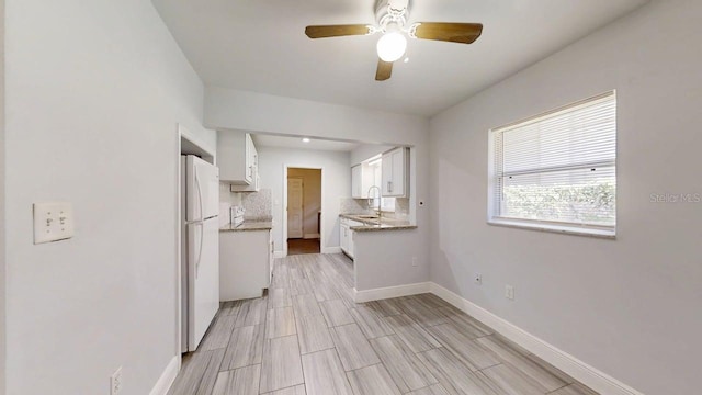 8609 N 11th St, Tampa, FL 33604 - kitchen featuring freestanding refrigerator, backsplash, white cabinetry, ceiling fan, and wood finish floors