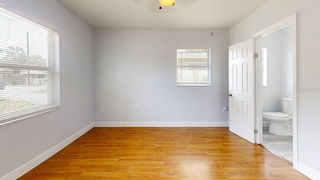 8609 N 11th St, Tampa, FL 33604 - unfurnished bedroom featuring multiple windows, light wood finished floors, and ensuite bath