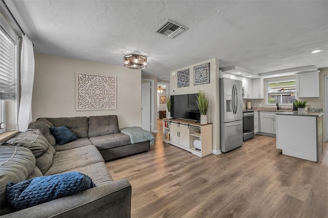 6053 11th Ave, New Port Richey, FL 34653 - living room with light wood-type flooring and recessed lighting