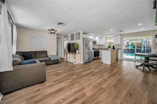 6053 11th Ave, New Port Richey, FL 34653 - living room featuring light wood-type flooring and recessed lighting