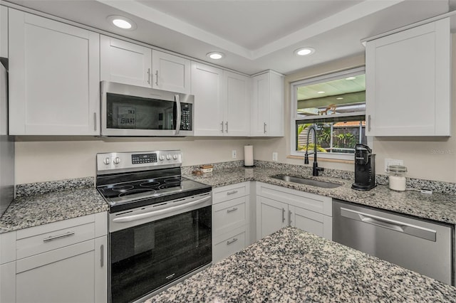 6053 11th Ave, New Port Richey, FL 34653 - kitchen with appliances with stainless steel finishes, recessed lighting, white cabinets, and light stone counters