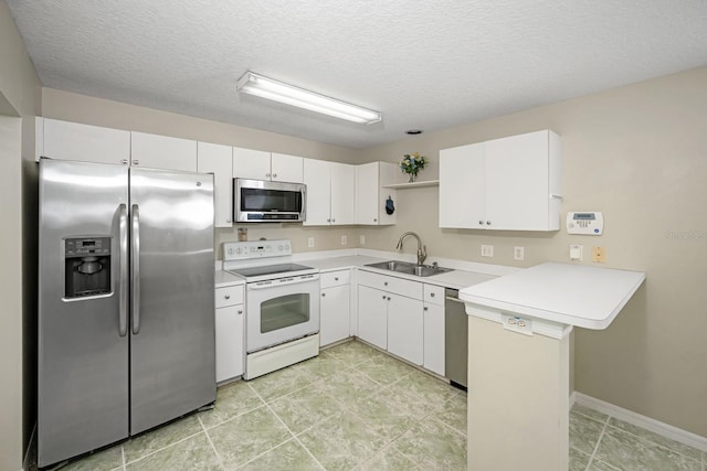 10807 Shasta Ct, Riverview, FL 33569 - kitchen featuring appliances with stainless steel finishes, a peninsula, light countertops, white cabinets, and a textured ceiling