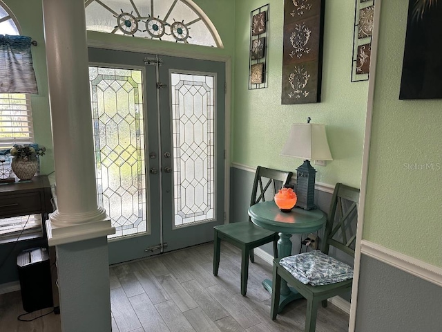 10920 Sailbrooke Dr, Riverview, FL 33579 - foyer entrance with decorative columns, french doors, wood finished floors, a textured wall, and healthy amount of natural light