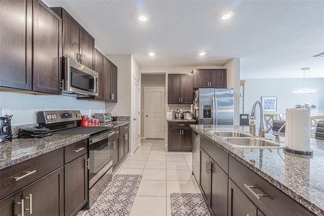 4954 Wild Senna Blvd, Tampa, FL 33619 - kitchen featuring appliances with stainless steel finishes, dark brown cabinets, a textured ceiling, dark stone countertops, and recessed lighting