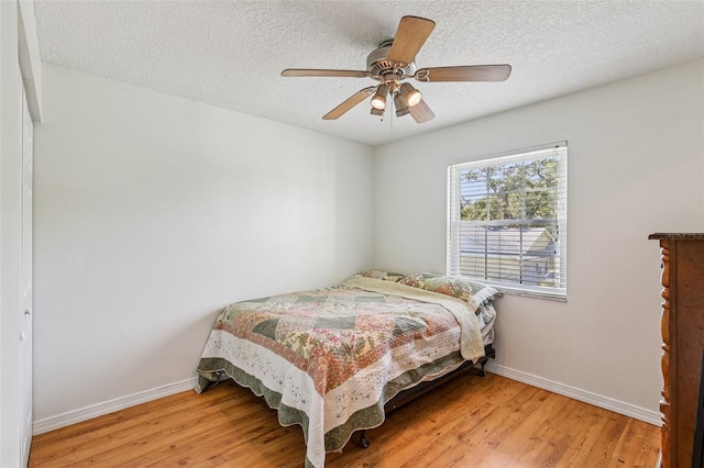 808 Franklin Cir, Palm Harbor, FL 34683 - bedroom featuring light wood-style floors, a textured ceiling, and a ceiling fan