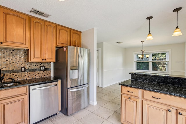808 Franklin Cir, Palm Harbor, FL 34683 - kitchen featuring stainless steel appliances, light tile patterned floors, tasteful backsplash, dark stone counters, and pendant lighting