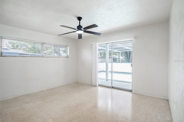 11830 86th Ave, Seminole, FL 33772 - unfurnished room with speckled floor, healthy amount of natural light, and a ceiling fan