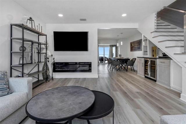 2630 St Josephs Dr W, Dunedin, FL 34698 - living room with wine cooler, stairs, light wood finished floors, a bar, and recessed lighting