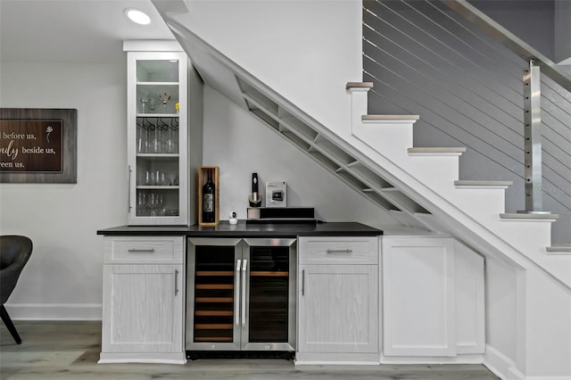 2630 St Josephs Dr W, Dunedin, FL 34698 - indoor dry bar with wine cooler, light wood-type flooring, and stairs