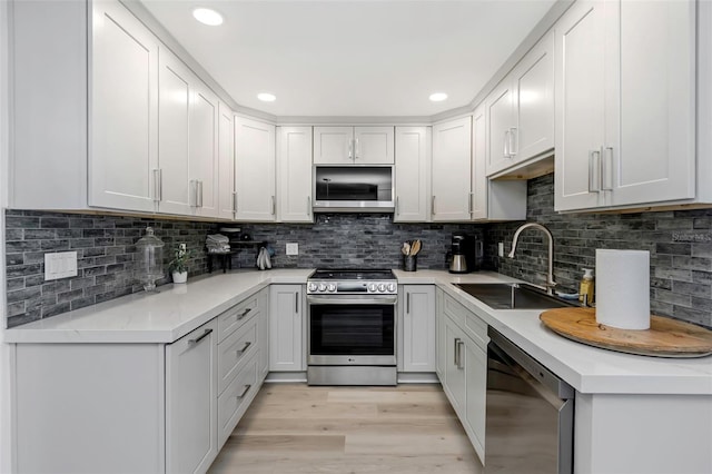 2630 St Josephs Dr W, Dunedin, FL 34698 - kitchen featuring appliances with stainless steel finishes, light wood-type flooring, light countertops, decorative backsplash, and recessed lighting