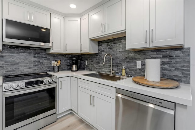 2630 St Josephs Dr W, Dunedin, FL 34698 - kitchen featuring stainless steel appliances, light countertops, backsplash, and white cabinetry