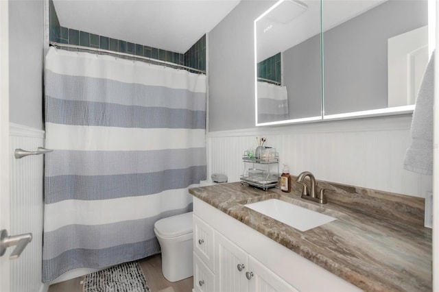 2630 St Josephs Dr W, Dunedin, FL 34698 - bathroom with vanity, a wainscoted wall, wood finished floors, and a shower with shower curtain