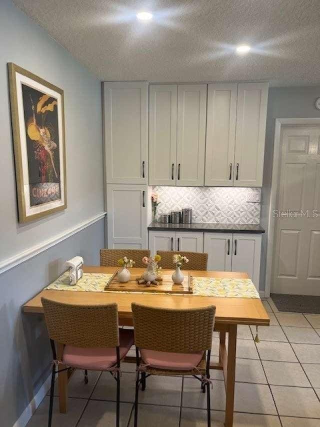 4487 Anderson Rd, Orlando, FL 32812 - dining room with a textured ceiling and light tile patterned floors