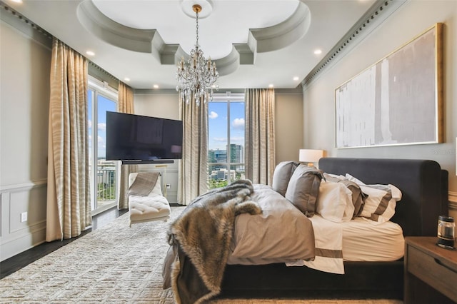 450 Knights Run Ave Unit 2004, Tampa, FL 33602 - bedroom with multiple windows, a chandelier, crown molding, wood finished floors, and a wainscoted wall