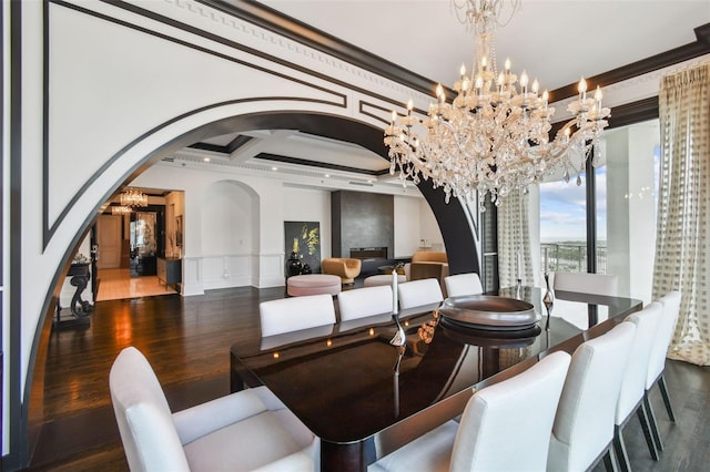 450 Knights Run Ave Unit 2004, Tampa, FL 33602 - dining space featuring arched walkways, a chandelier, crown molding, wood finished floors, and a decorative wall