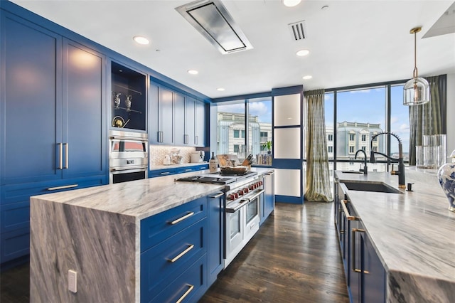 450 Knights Run Ave Unit 2004, Tampa, FL 33602 - kitchen featuring blue cabinets, light stone counters, range with two ovens, glass insert cabinets, and dark wood finished floors