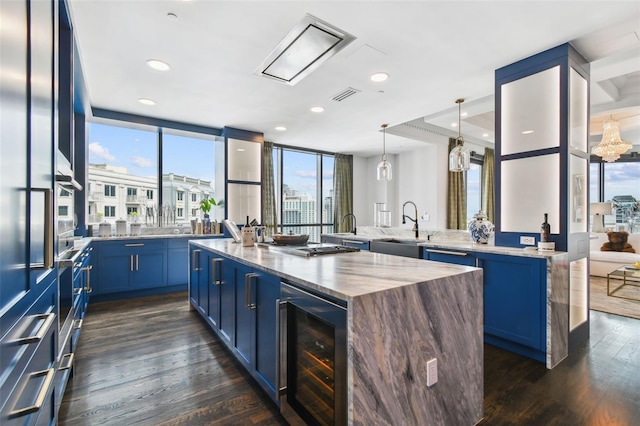 450 Knights Run Ave Unit 2004, Tampa, FL 33602 - kitchen featuring beverage cooler, a large island with sink, blue cabinetry, dark wood finished floors, and recessed lighting