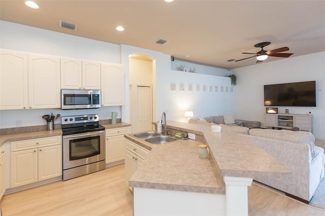228 Taylor Bay Ln, Brandon, FL 33510 - kitchen with appliances with stainless steel finishes, open floor plan, light wood-style flooring, ceiling fan, and light countertops