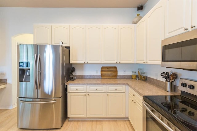 228 Taylor Bay Ln, Brandon, FL 33510 - kitchen with appliances with stainless steel finishes, light wood-style floors, white cabinets, and light countertops