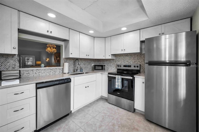 970 Virginia St Unit 109, Dunedin, FL 34698 - kitchen featuring appliances with stainless steel finishes, light countertops, white cabinetry, decorative backsplash, and recessed lighting