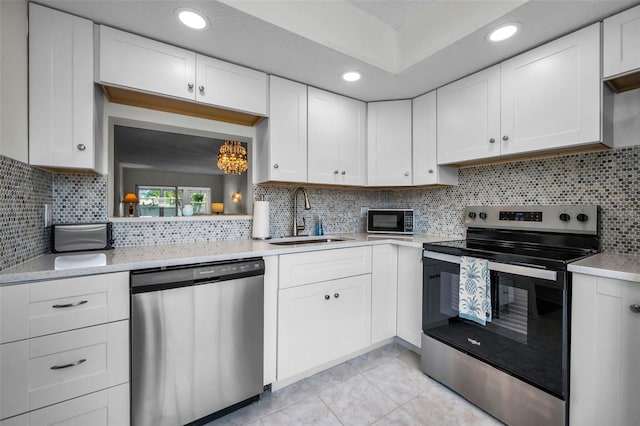 970 Virginia St Unit 109, Dunedin, FL 34698 - kitchen featuring stainless steel appliances, light tile patterned flooring, white cabinets, tasteful backsplash, and recessed lighting