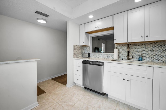 970 Virginia St Unit 109, Dunedin, FL 34698 - kitchen with stainless steel dishwasher, light countertops, decorative backsplash, white cabinetry, and light tile patterned floors