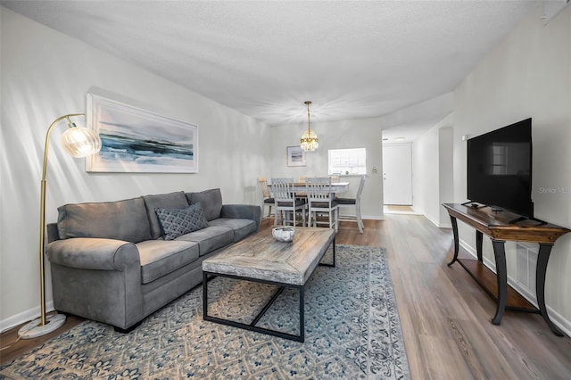 970 Virginia St Unit 109, Dunedin, FL 34698 - living room featuring wood finished floors, a chandelier, and a textured ceiling