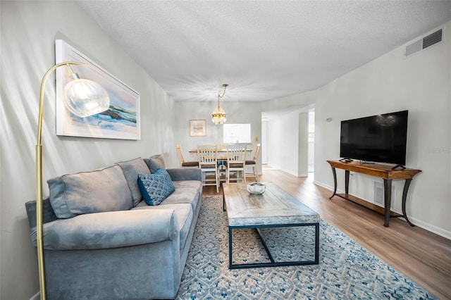 970 Virginia St Unit 109, Dunedin, FL 34698 - living room featuring wood finished floors, a chandelier, and a textured ceiling