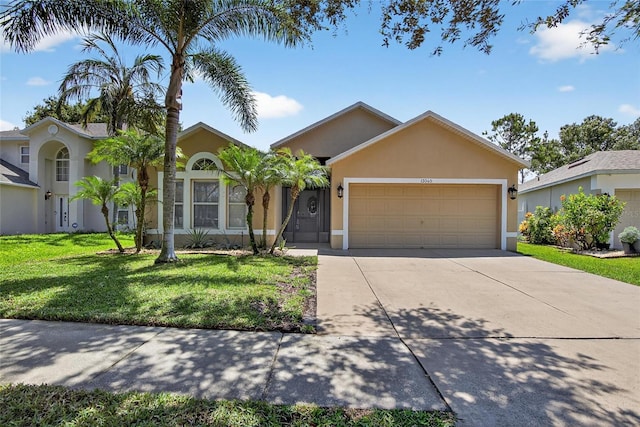 13040 Waterbourne Dr, Gibsonton, FL 33534 - ranch-style house featuring a garage, stucco siding, a front yard, and driveway